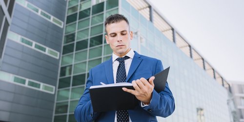 homme devant immeuble costume